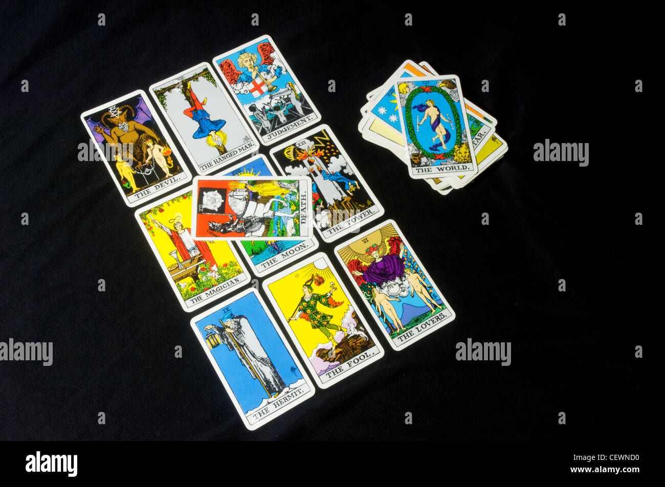 Tarot cards layed out in a square with the Death card in the middle and a pack of cards on the side with the World card on top Stock Photo