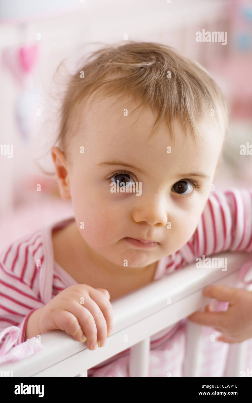 A Female Baby With Fair Hair Wearing A Pink Striped Top Standing