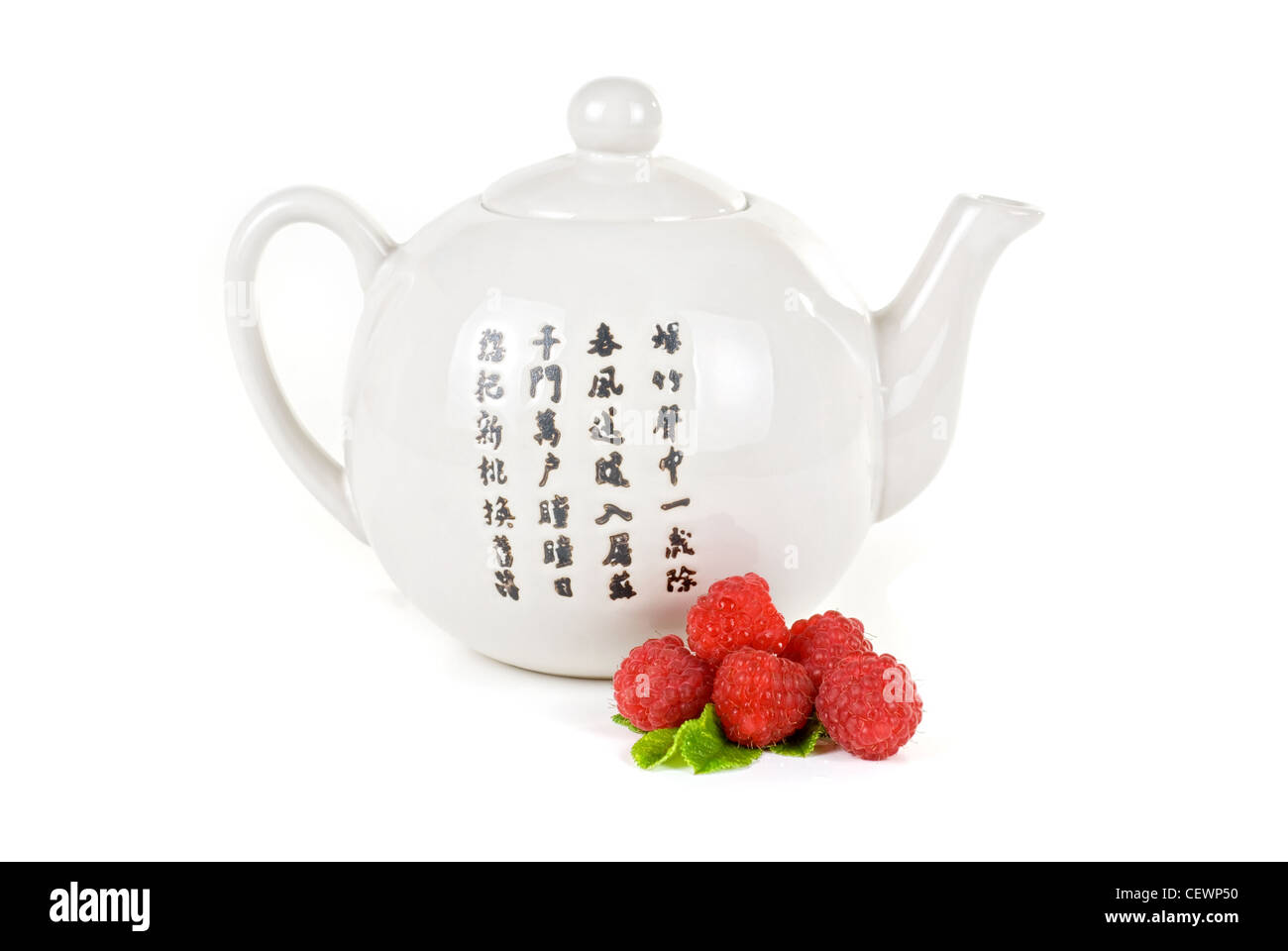 Teapot with fruit tea and berries on a white background Stock Photo