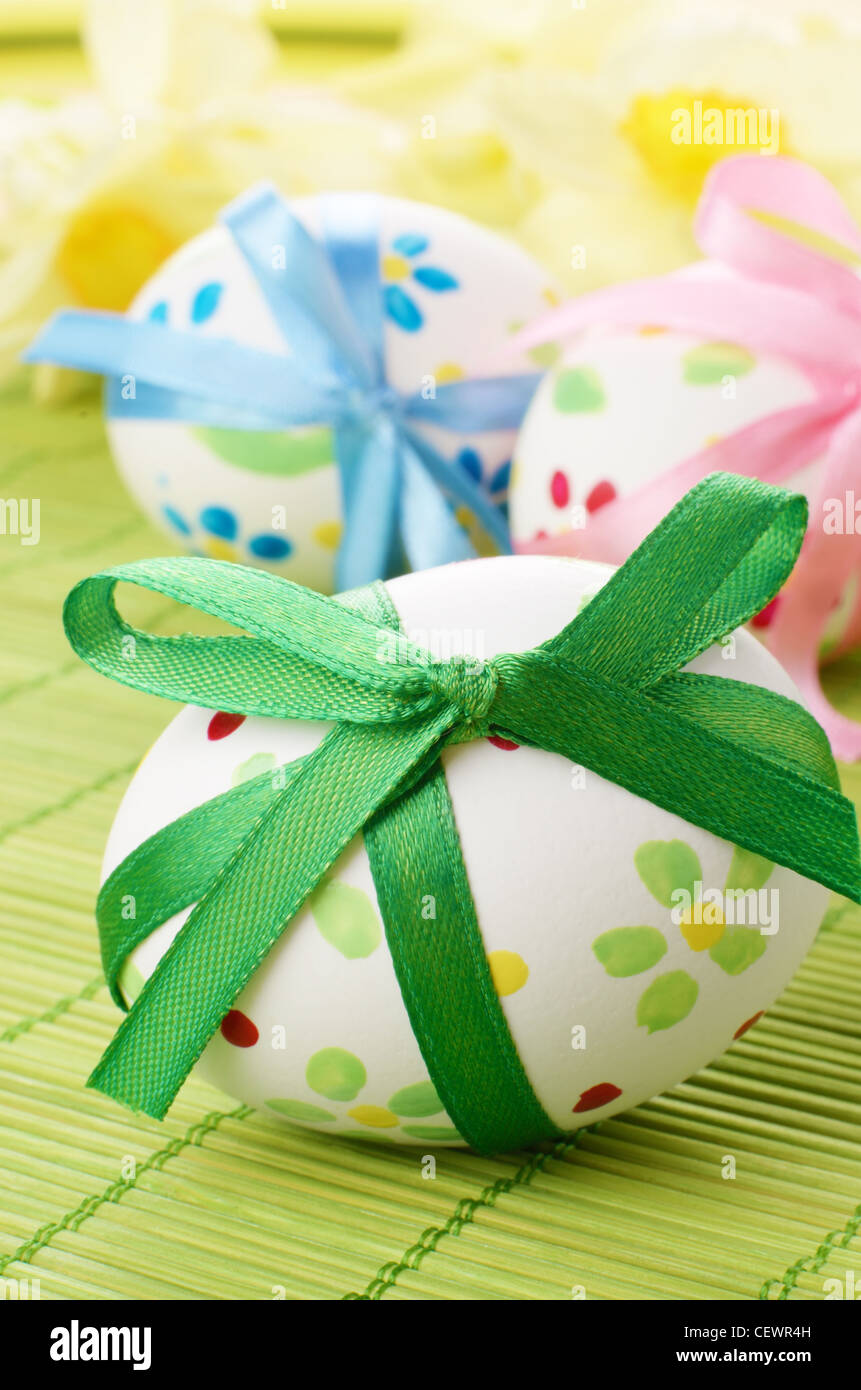 Easter eggs with bows over floral background Stock Photo - Alamy