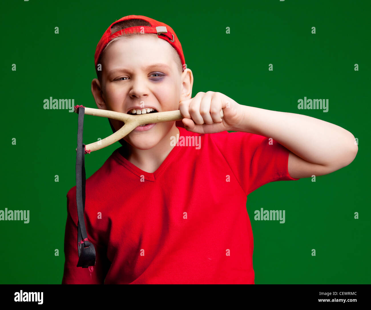 naughty boy with a slingshot, against green background Stock Photo Alamy