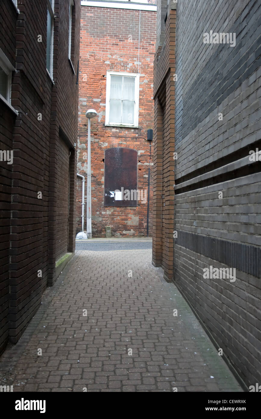 Block paved alleyway leading to a back street . Stock Photo