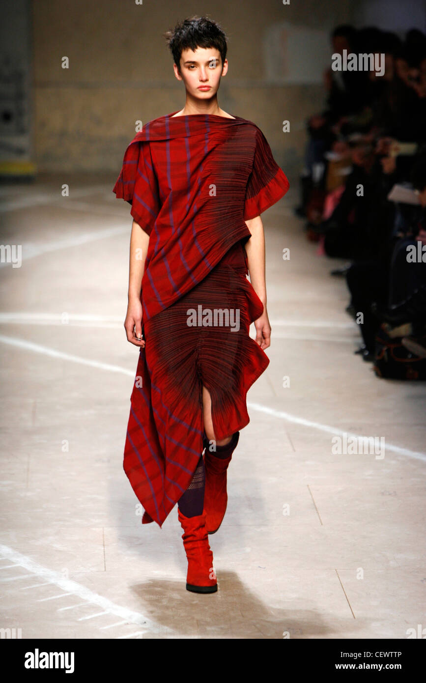 Issey Miyake Paris Ready to Wear Autumn Winter Model wearing red and blue check dress crinkle fabric red boots Stock Photo Alamy