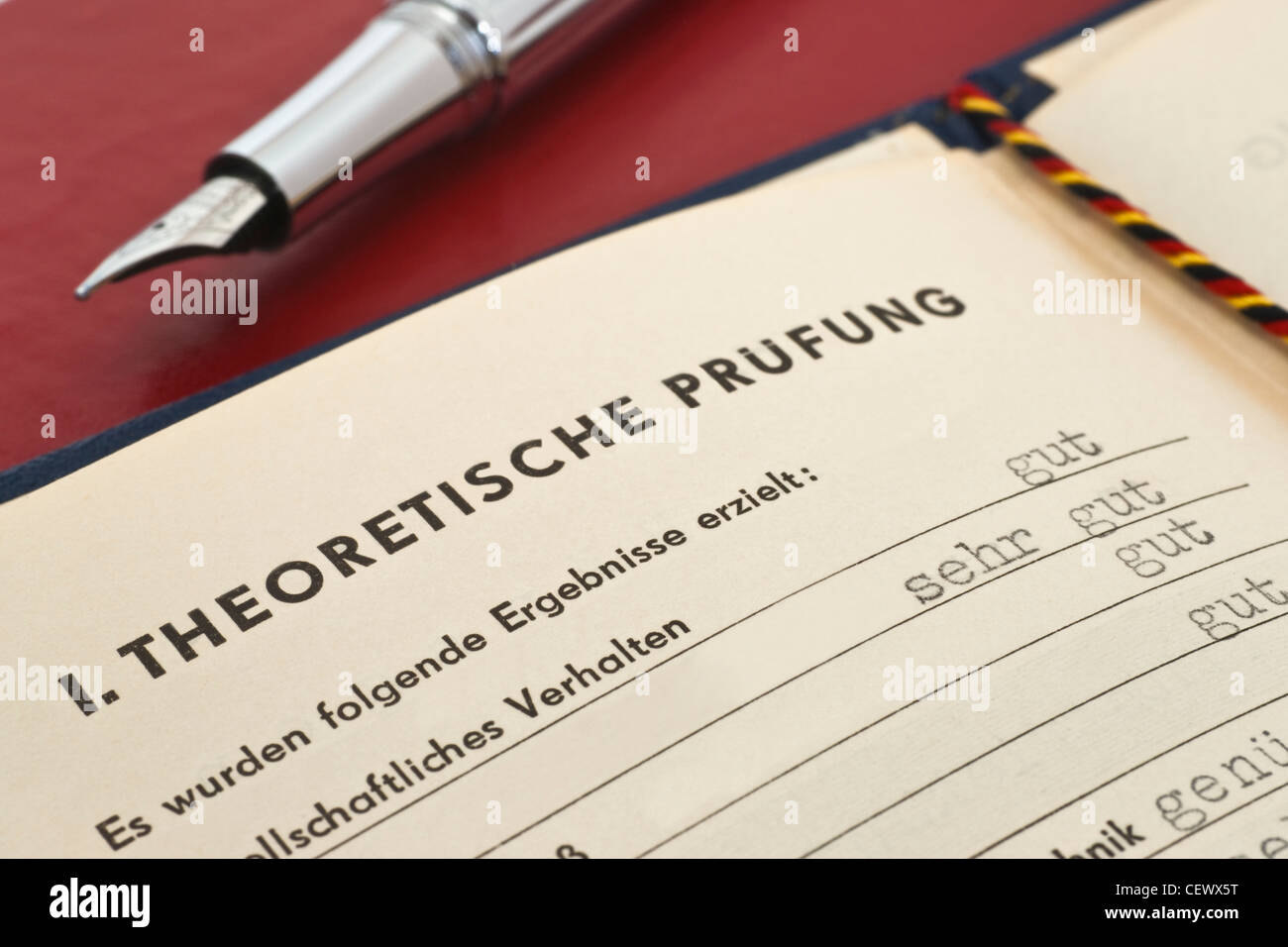 GDR craft certificate from 1954, the page of the theoretical test is opened, a fountain pen is alongside Stock Photo