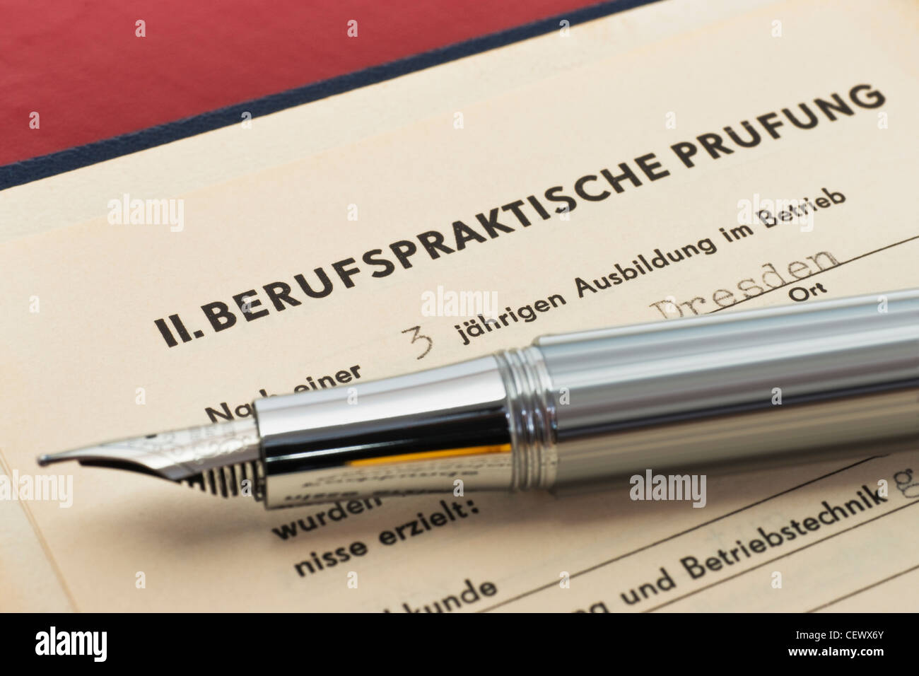 GDR craft certificate from 1954, the page of the work practical test is opened, a fountain pen is alongside Stock Photo