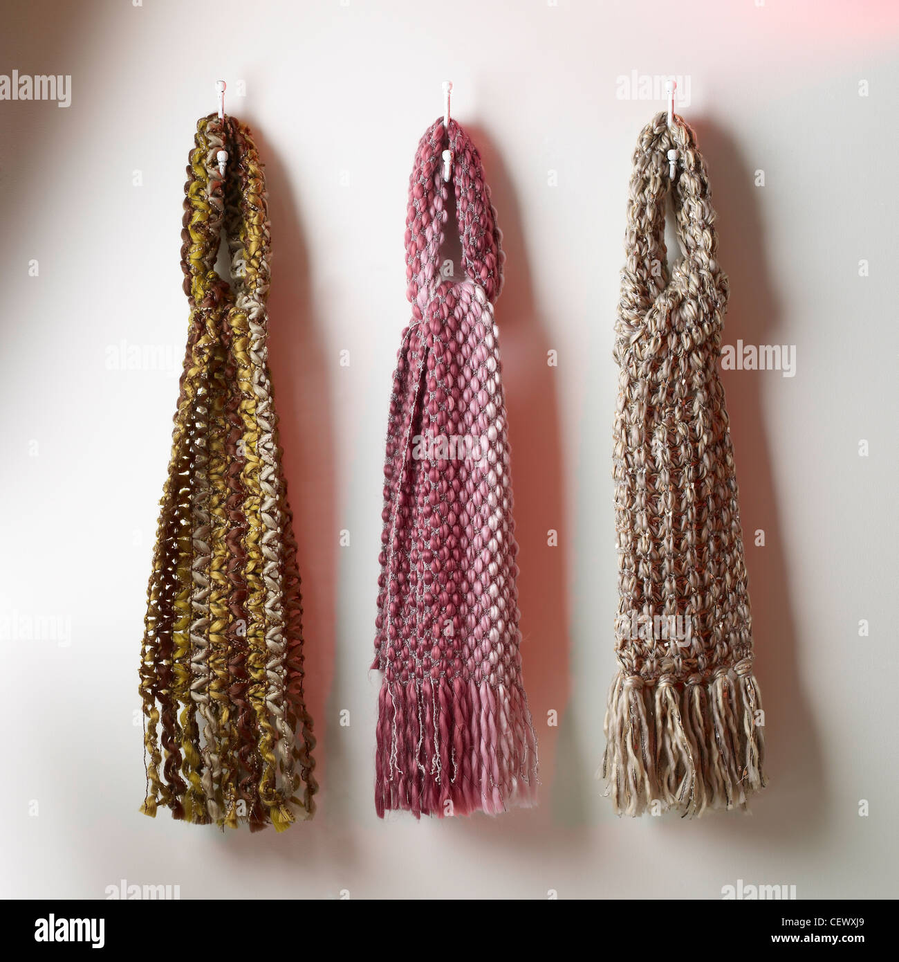 A still life shot of colourful wool scarves lined up on a plain background Stock Photo