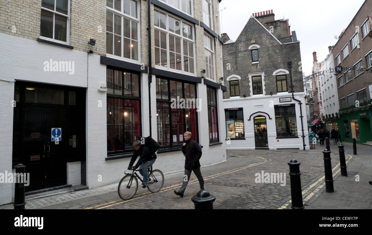 Trendy shops, cyclist and pedestrian on Newburgh Street near Carnaby Street in the Newburgh Quarter London England Stock Photo
