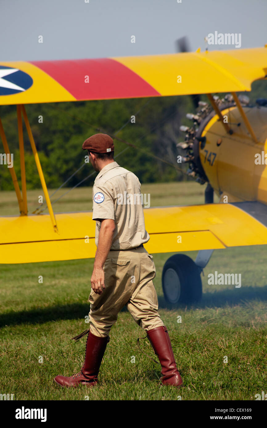 A pilot walks past a biplane taking off at the Flying Circus exhibition, Bealeton, Virginia. Stock Photo