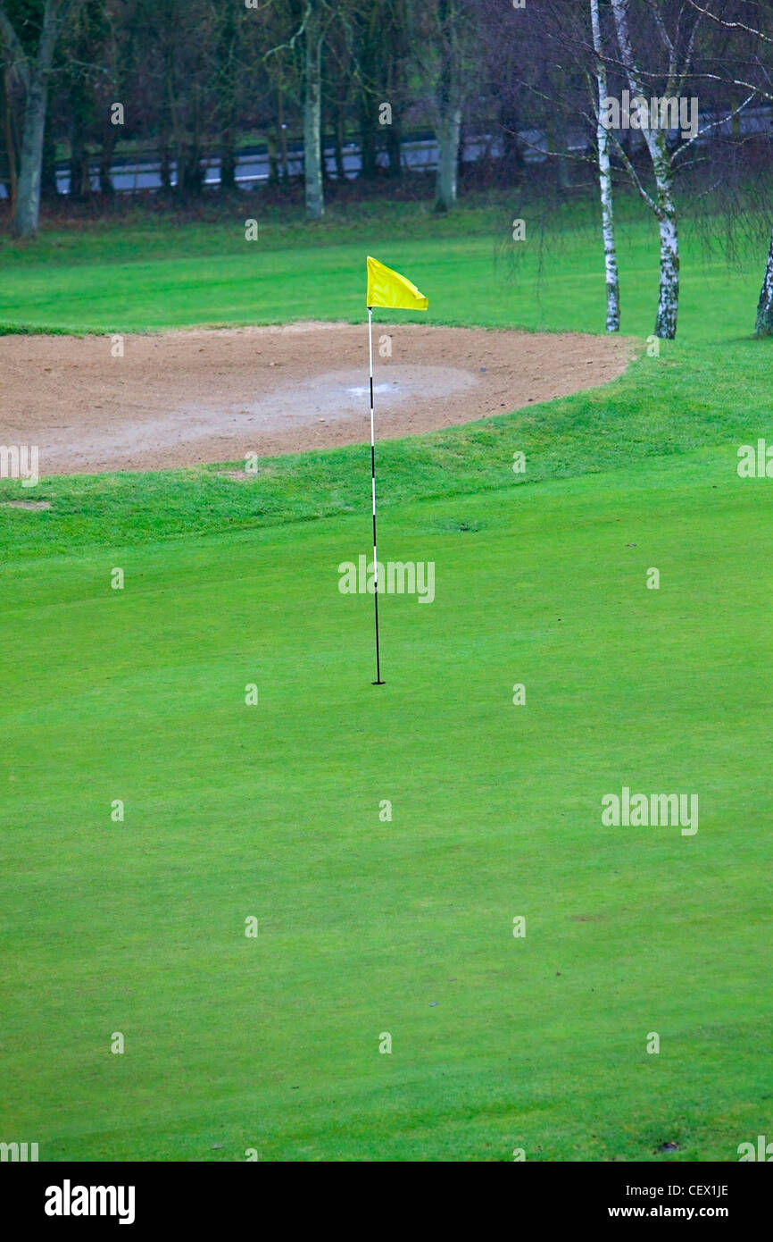 Flag stick on golf hole and sand bunker on a golf course Stock Photo