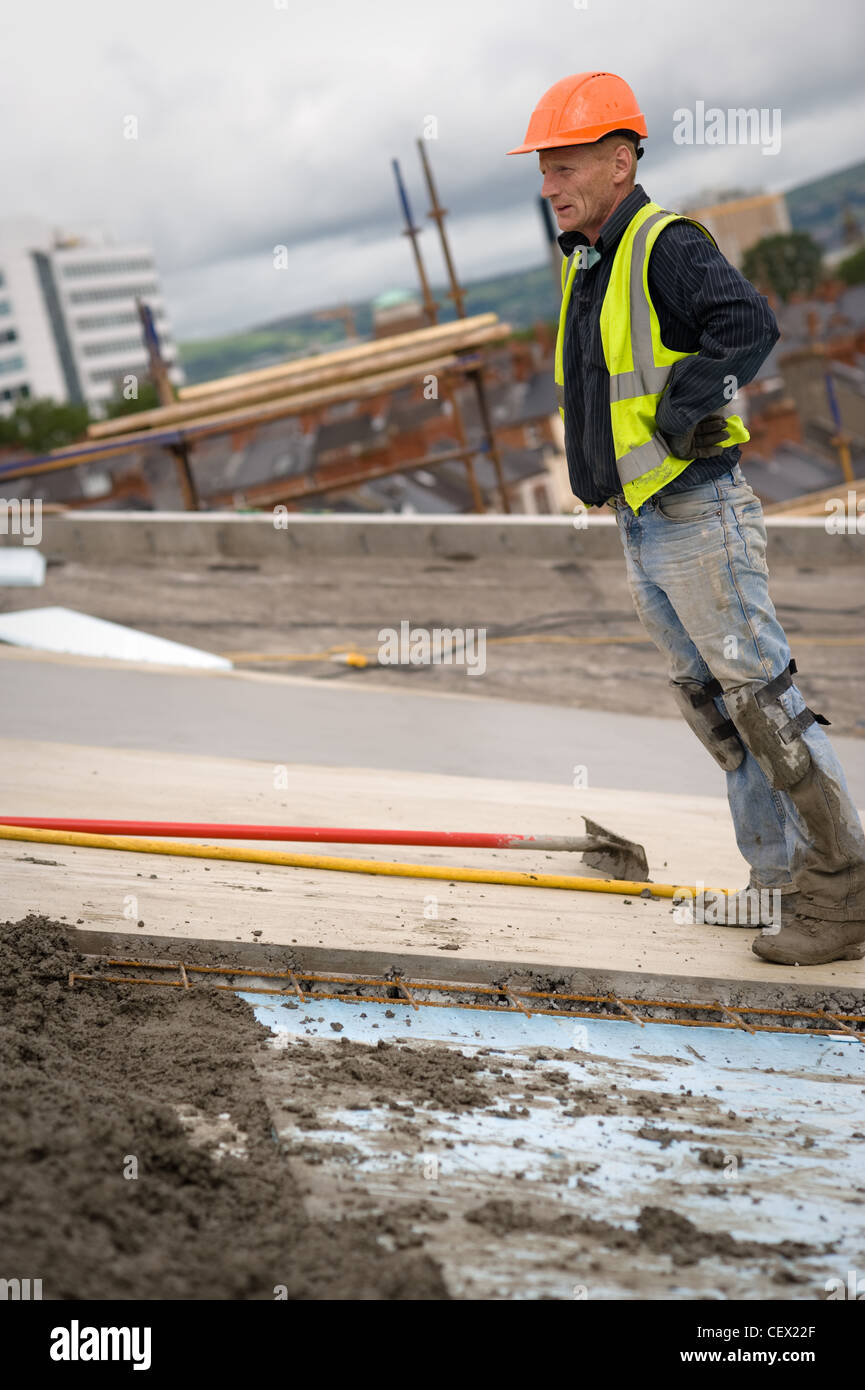 workmen pouring cement on building site Stock Photo