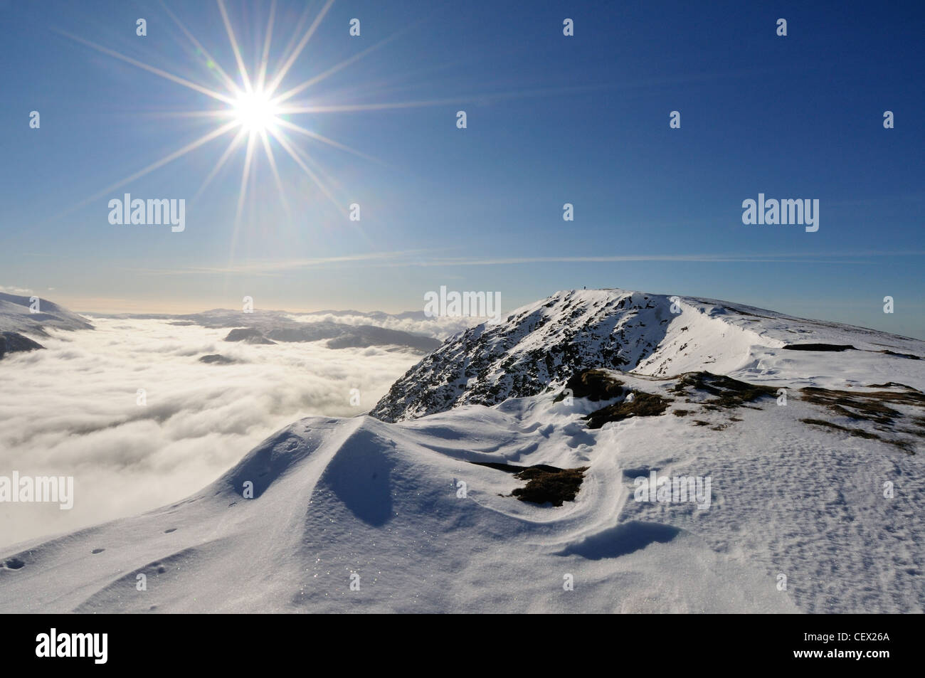 Winter sun and the summit of Blencathra above a temperature inversion in the English Lake District Stock Photo