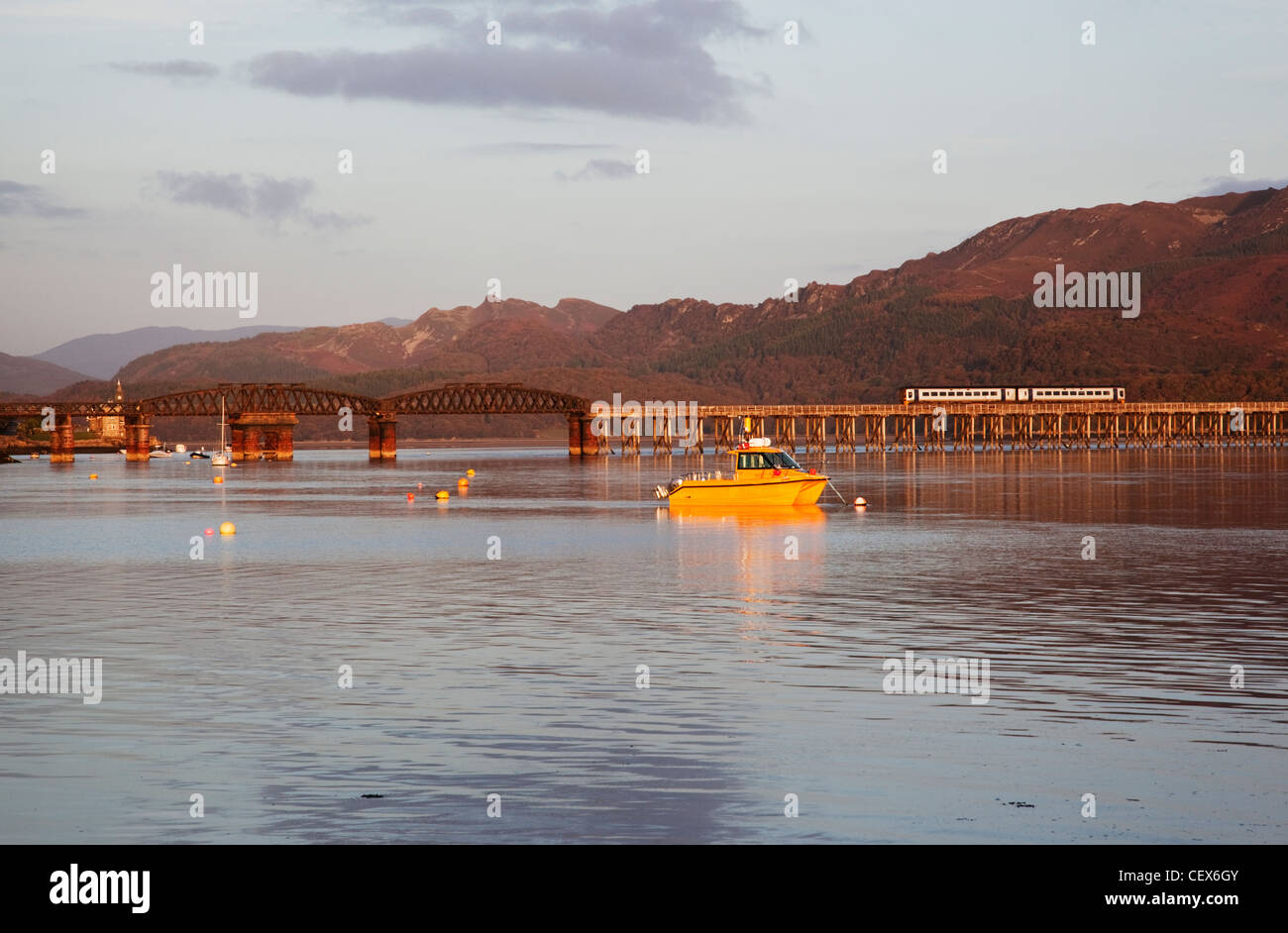 Barmouth harbour and railway bridge - a train is crossing the bridge. Stock Photo