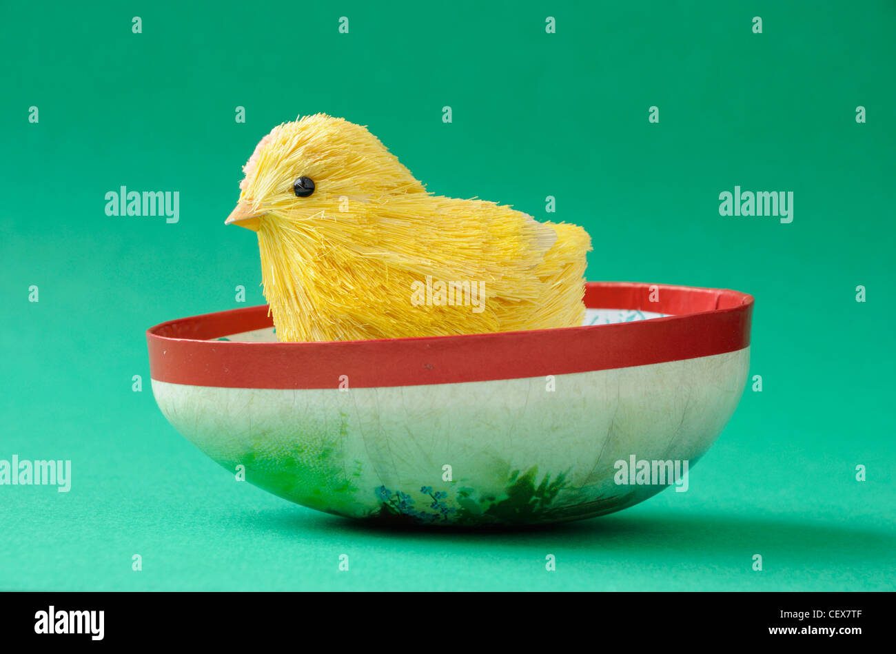 Easter chick emerging from half a painted egg Stock Photo