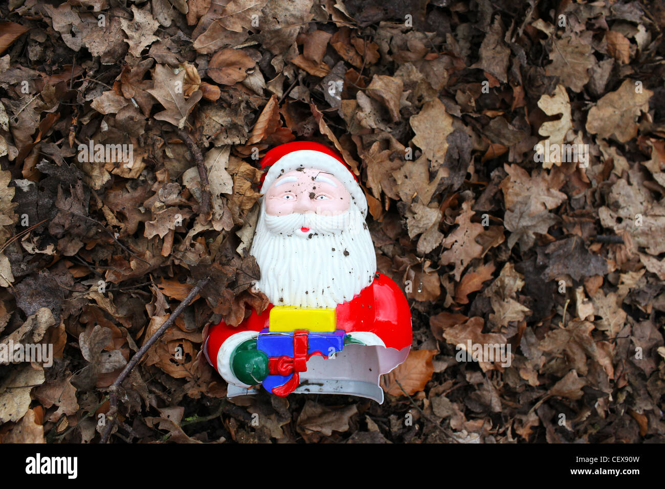 Broken Santa toy in fallen leaves Stock Photo