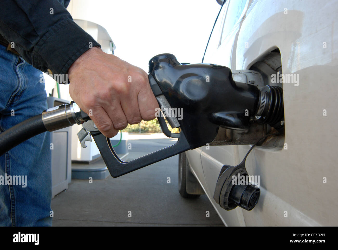 Close up of a customer's hand pumping fuel into car's gas tank Stock