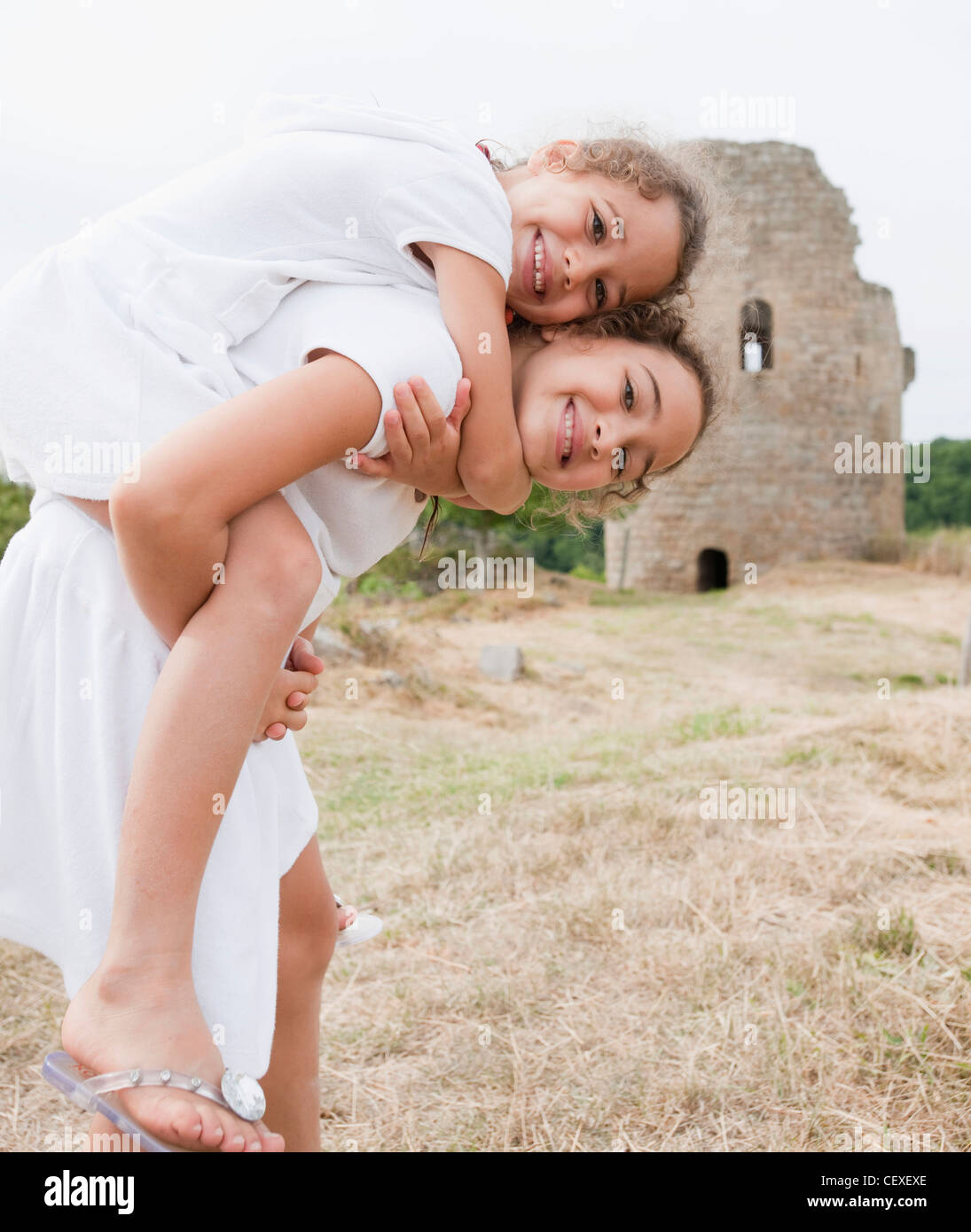 narrow Vacation Permission Girl giving piggyback to her sister and smiling hi-res stock photography  and images - Alamy