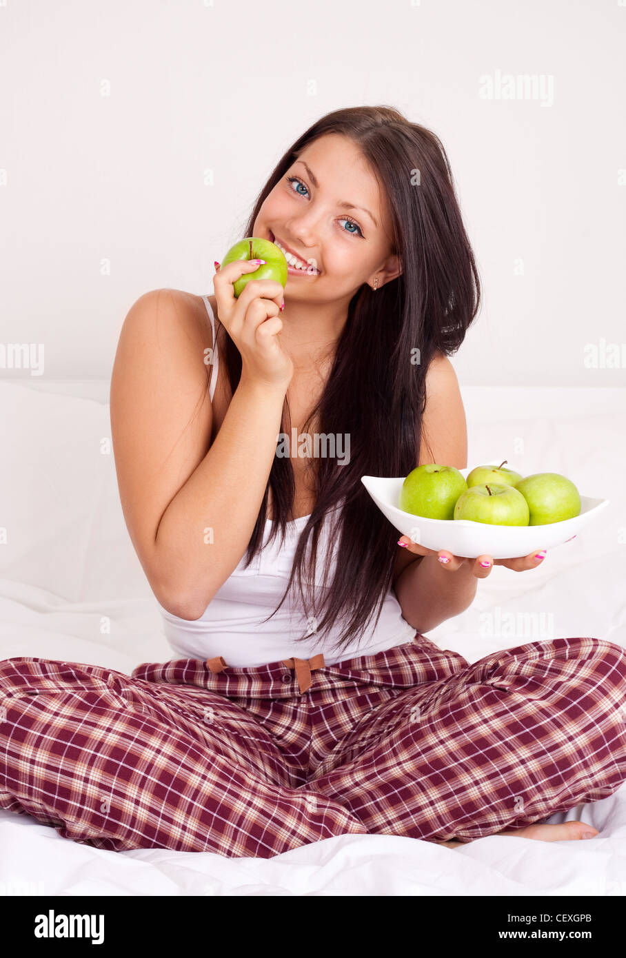 young woman eating apples in bed at home Stock Photo Alamy