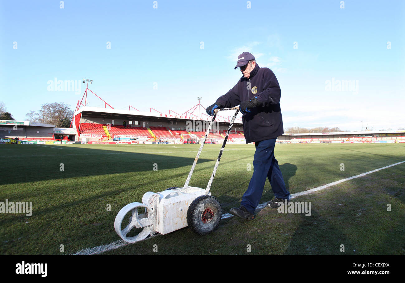 A groundsman paints the lines on the pitch at the Broadfield Stadium Crawley. Picture by James Boardman Stock Photo