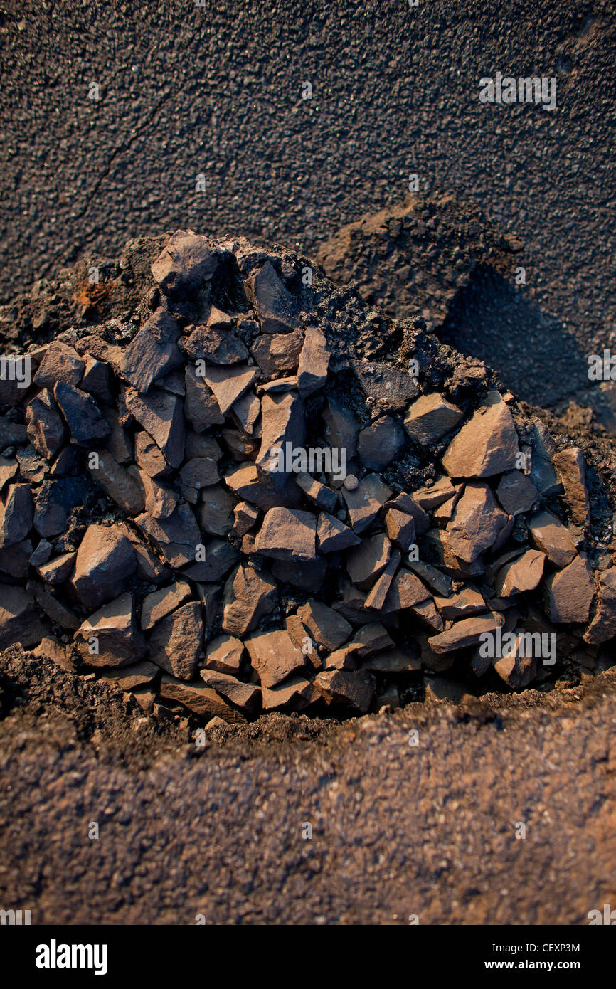 Asphalt, rocks, pavement, graphic image, dramatic light. Representing construction, building, grays, black, tan muted colors Stock Photo