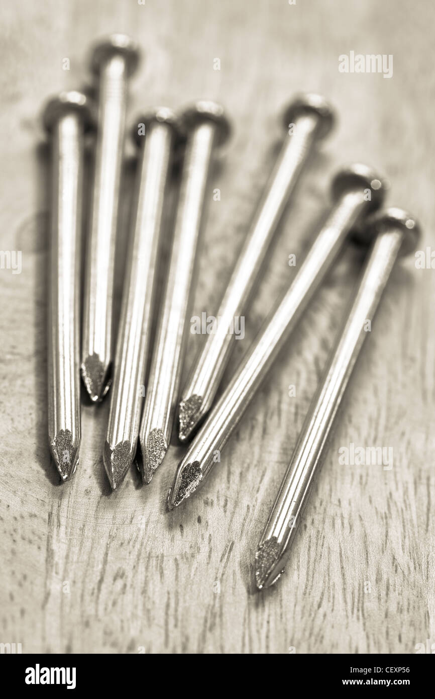 Monochrome shot of a nails on the wooden table. Shallow DOF. Stock Photo