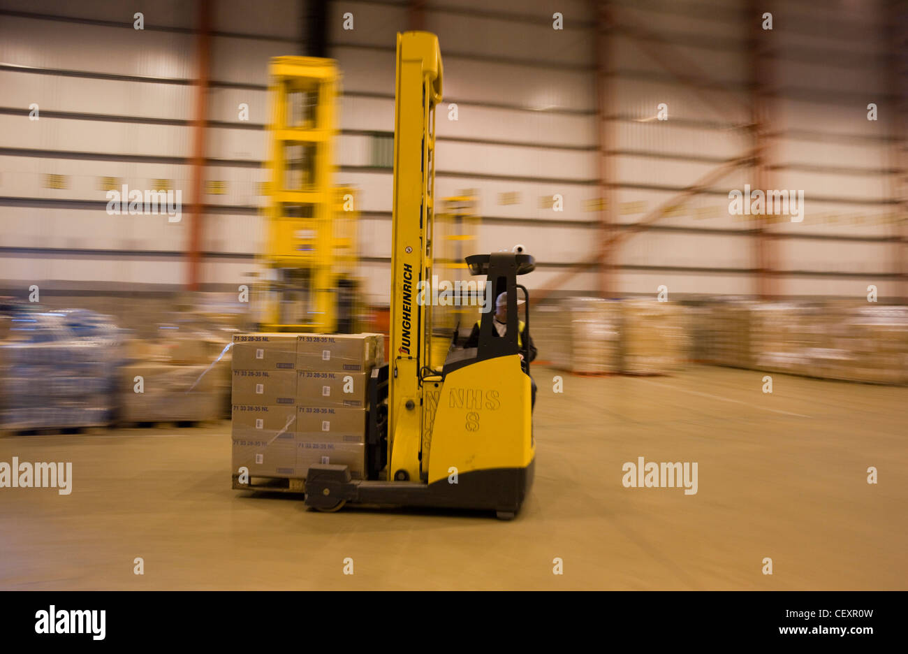 A forklift truck speeding round the DHL & NHS Distribution warehouse, Corby. Stock Photo