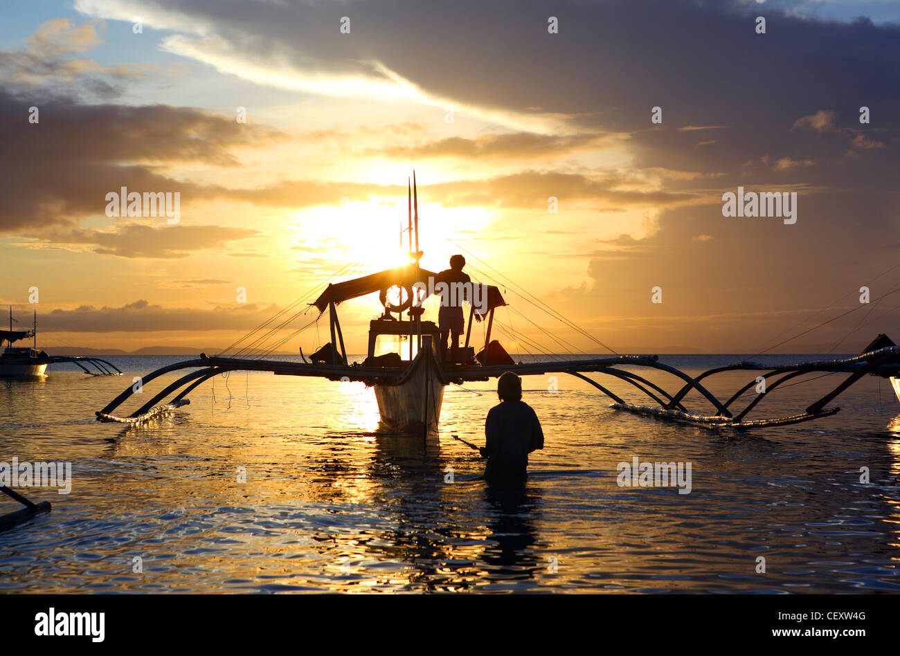 Fishermen on outrigger fishing boat at sunset. Donsol, Sorsogon, Luzon, Albay, Bicol, Philippines, South-East Asia, Asia Stock Photo