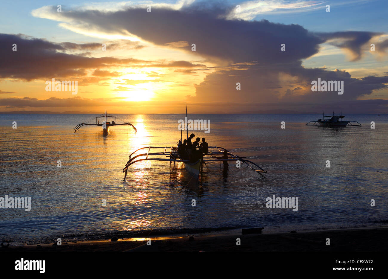 Fishermen on outrigger fishing boat at sunset. Donsol, Sorsogon, Luzon, Albay, Bicol, Philippines, South-East Asia, Asia Stock Photo
