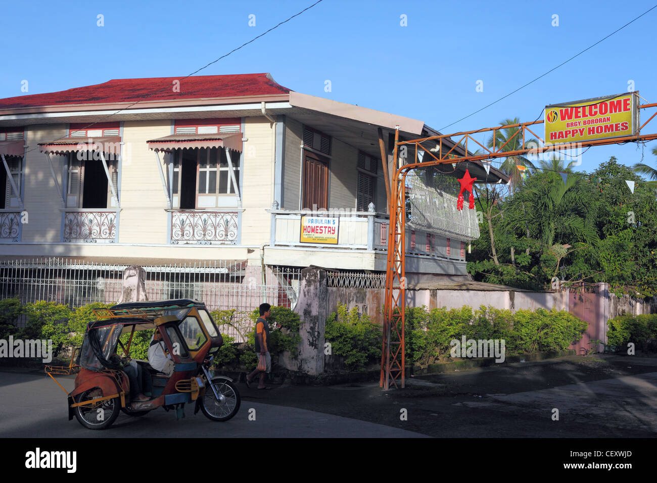 Motor taxi passes colonial house. Donsol, Sorsogon, Luzon, Albay, Bicol, Philippines, South-East Asia, Asia Stock Photo