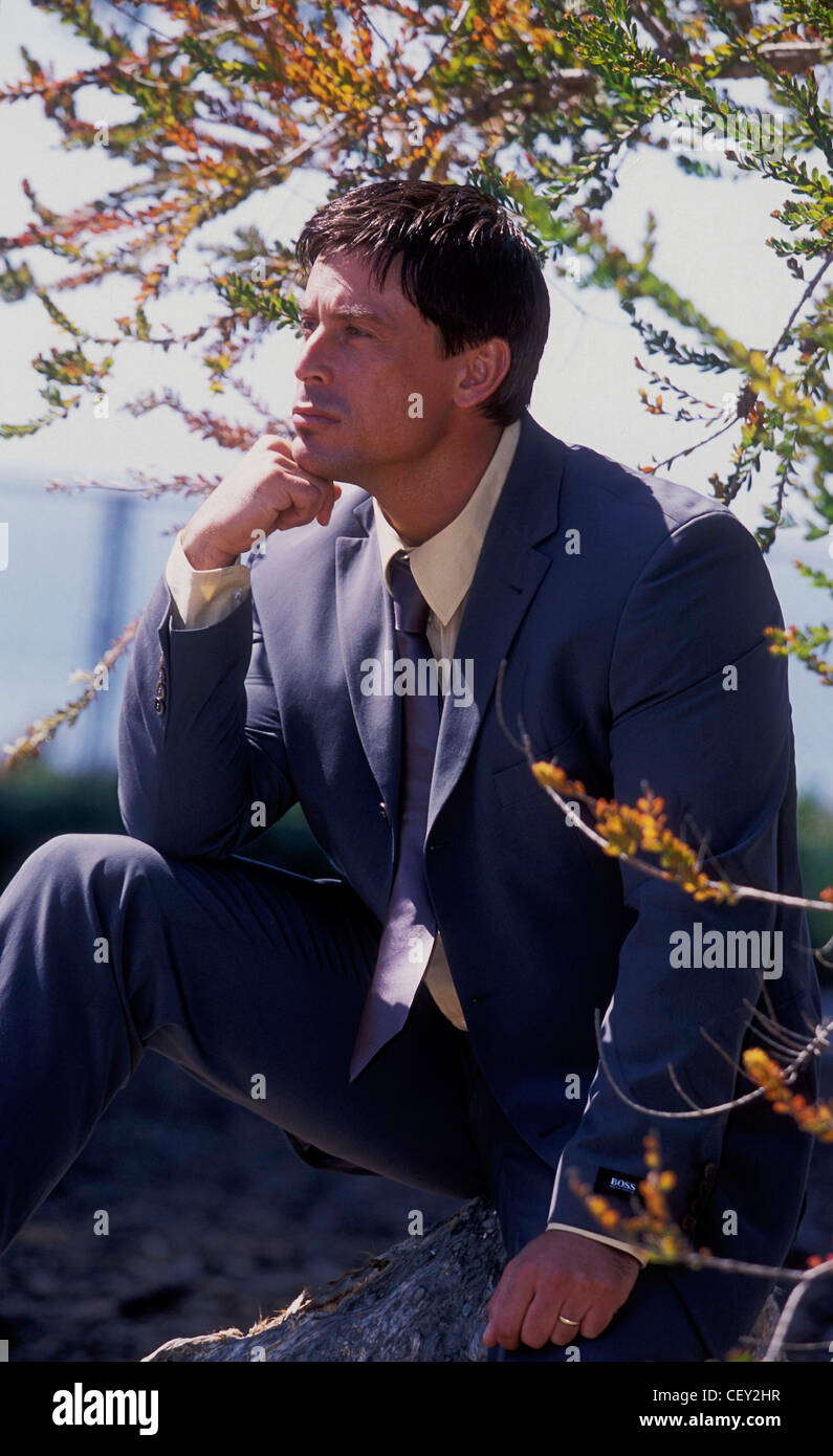 Male Short Brown Hair Wearing Grey Suit And Tie Yellow Shirt