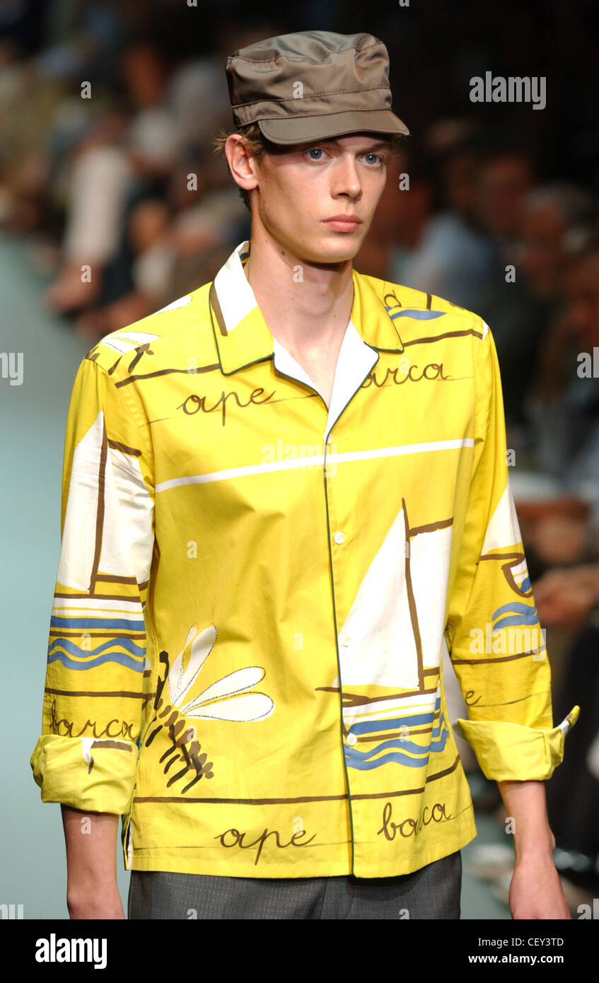 Prada Menswear Ready to Wear Spring Summer Model short brown hair wearing  brown hat, yellow shirt brown writing and white and Stock Photo - Alamy