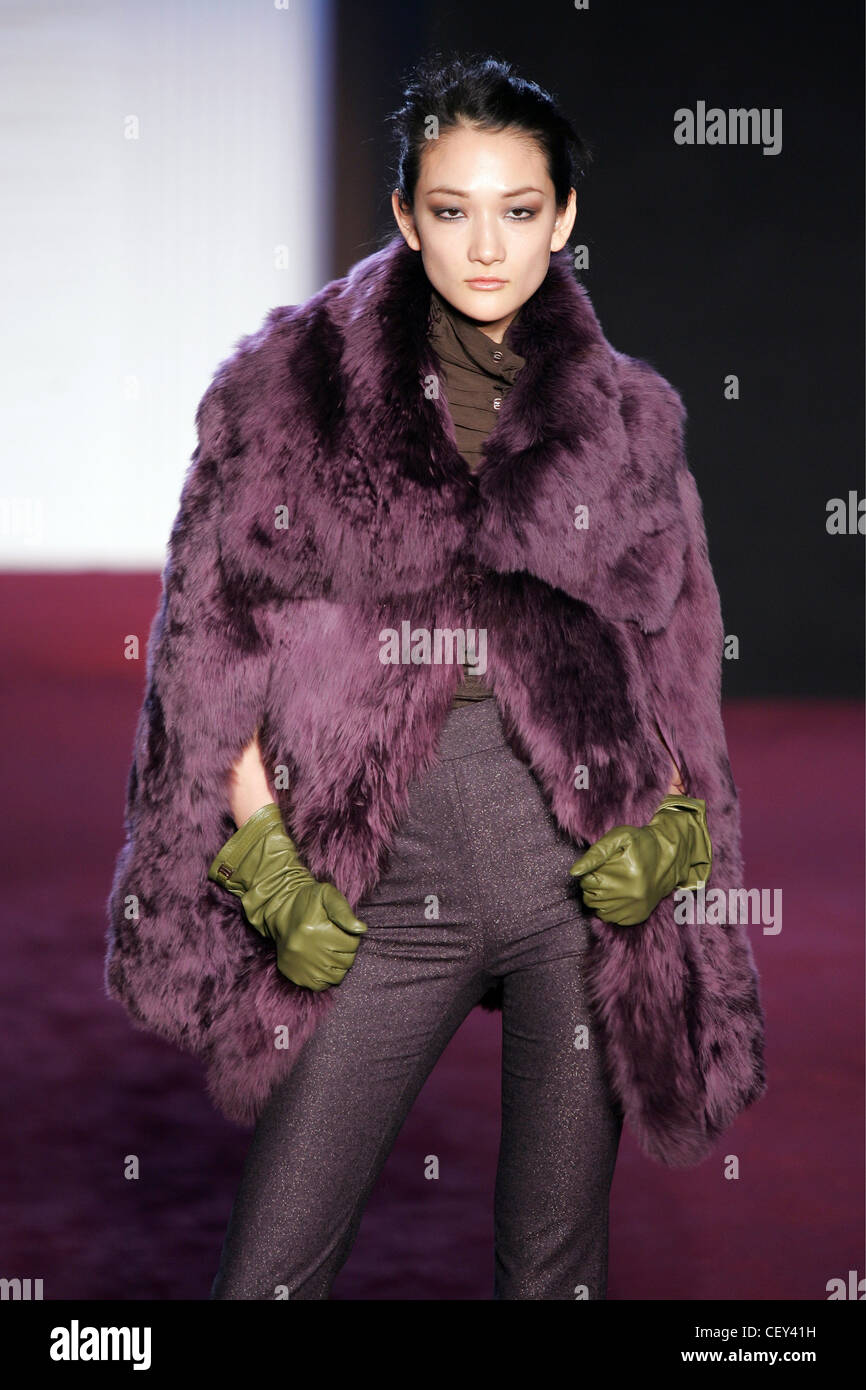 låg på hypotese Brunette model with hair tied back wearing a purple fur coat, purple  trousers and green leather gloves Stock Photo - Alamy