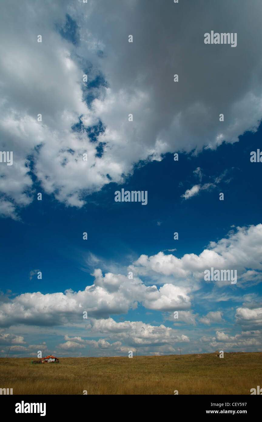 Landscape with little house, blue sky and clouds Stock Photo - Alamy