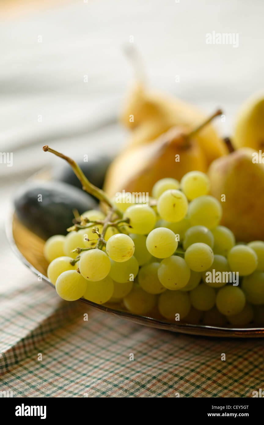 Ripe autumn grapes and pears in a dish close-up Stock Photo