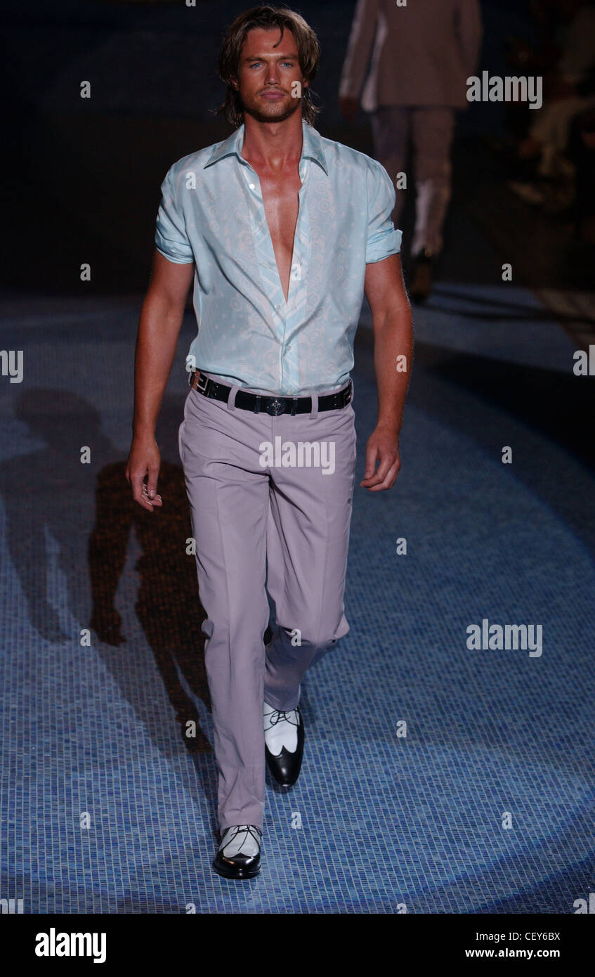 Versace Milan Menswear S S Male wearing patterned blue shirt with rolled  sleeves and purple trousers Dark runway Stock Photo - Alamy