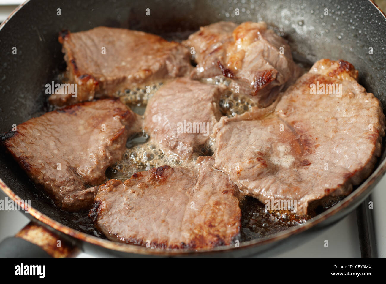 Frying fresh veal fillet in a frying pan Stock Photo