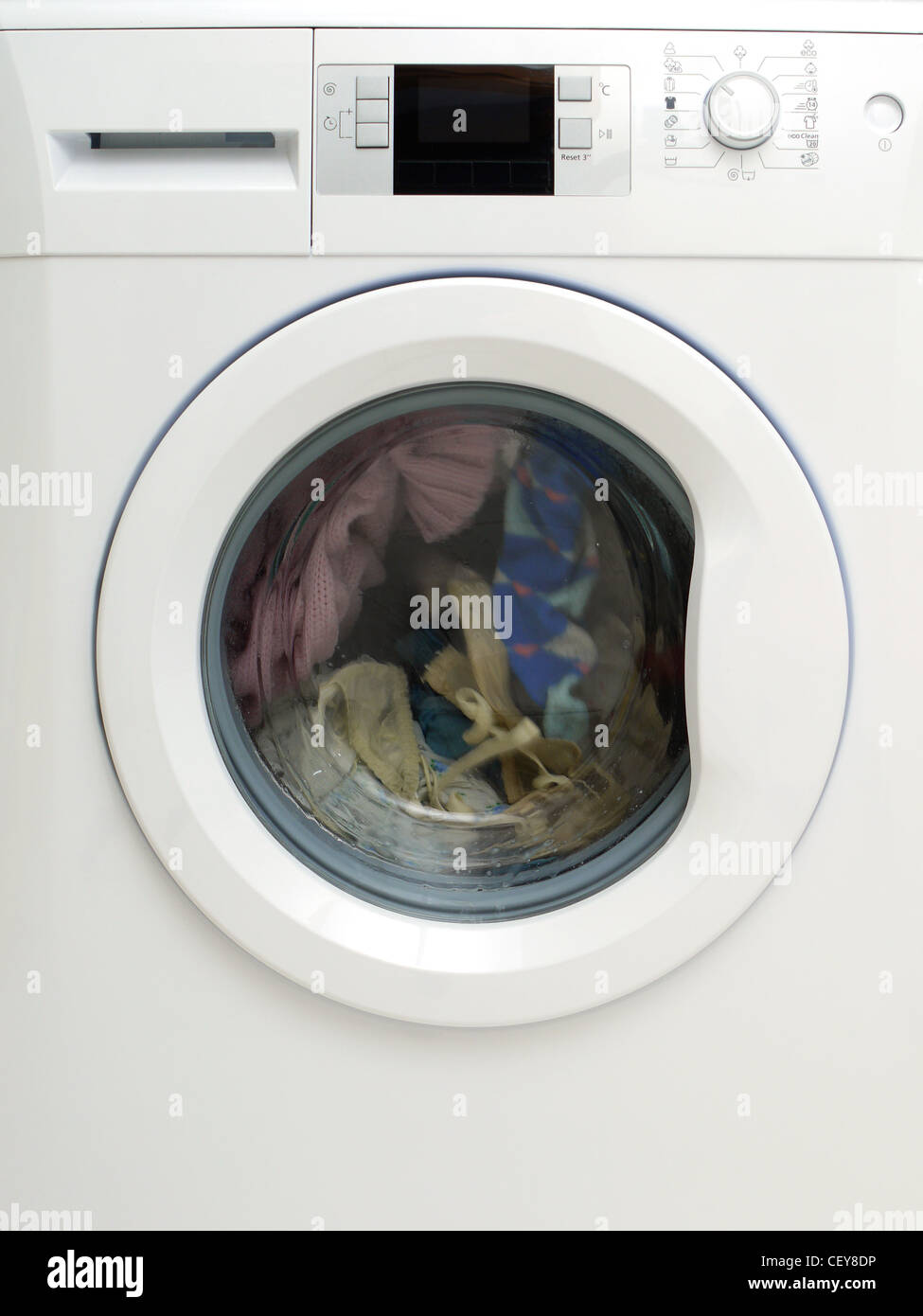 Dirty clothing being washed in washing machine Stock Photo