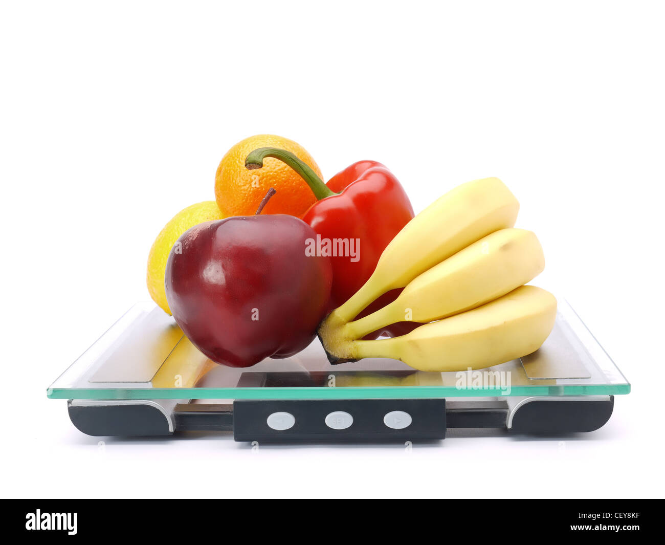 Bunch of fresh fruits and vegetables on glass bathroom scales shot on white Stock Photo