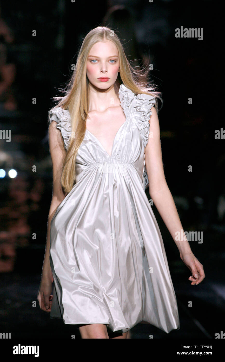 Model Tanya Dziahileva very long straight blonde hair wearing white satin sleeveless dress ruched and pinned sleeves, plunging Stock Photo