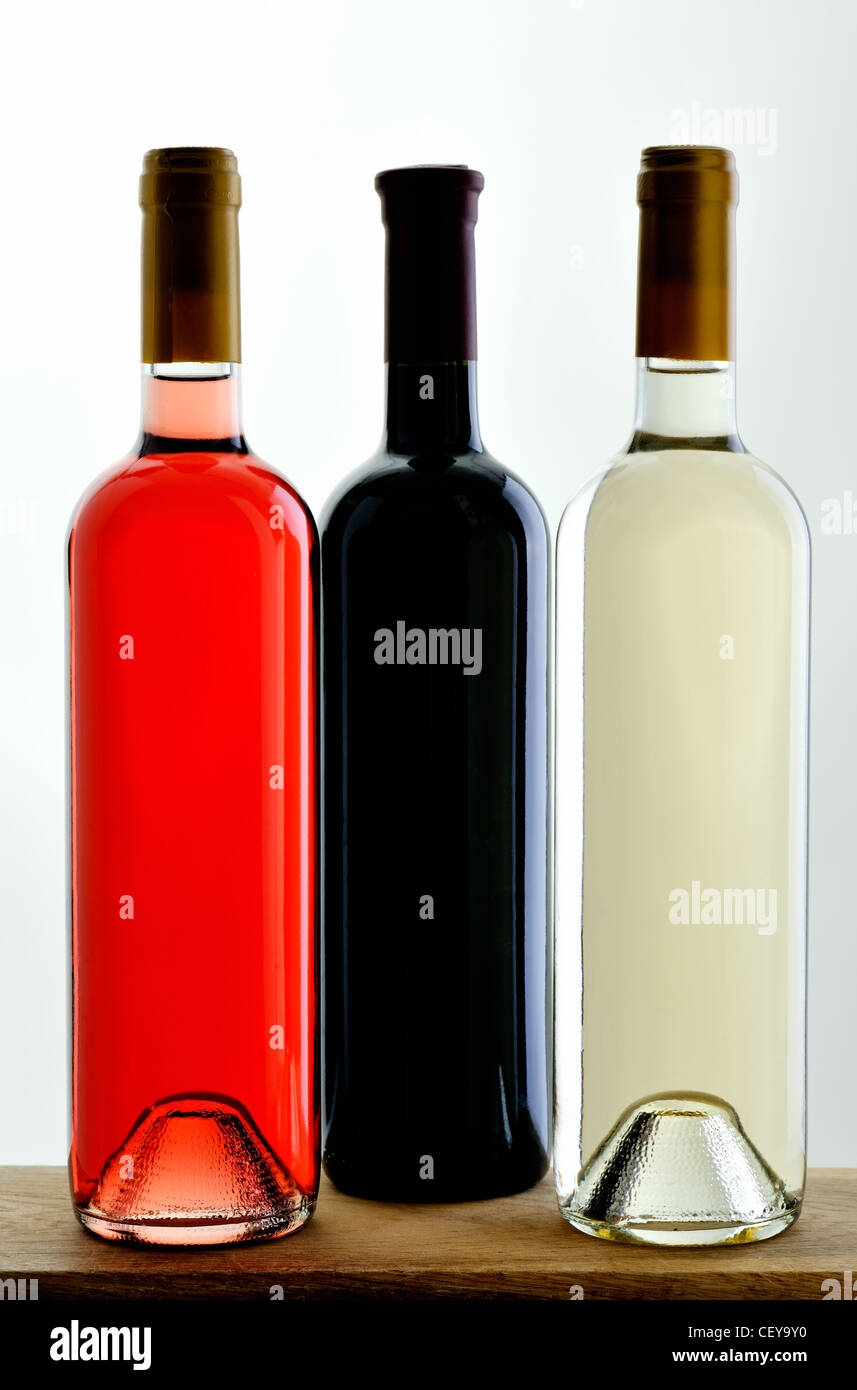 Three random bottles of red, black and white wine, sealed without labels Stock Photo