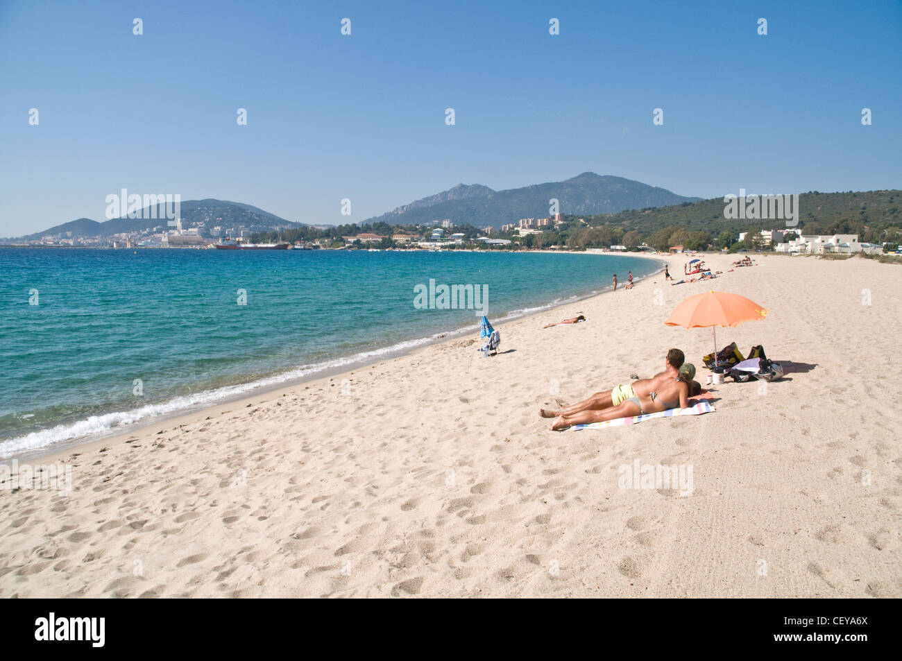 A vacationing couple enjoying the quiet at an empty Mediterranean sandy beach in the off-season, near Ajaccio, island of Corsica, France. Stock Photo