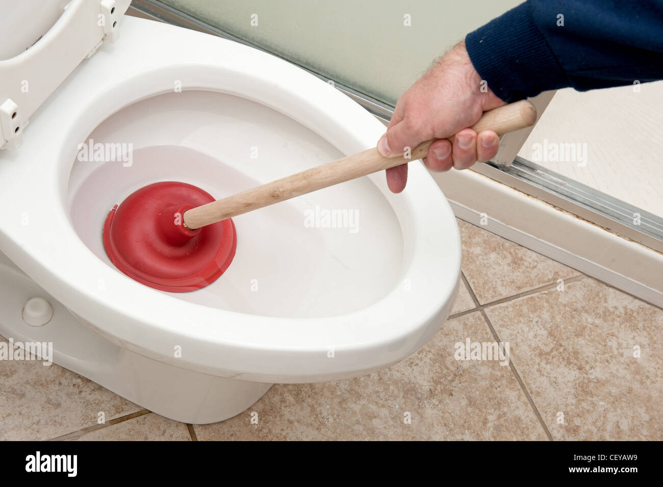 https://c8.alamy.com/comp/CEYAW9/a-plumber-uses-a-plunger-to-unclog-a-toilet-CEYAW9.jpg