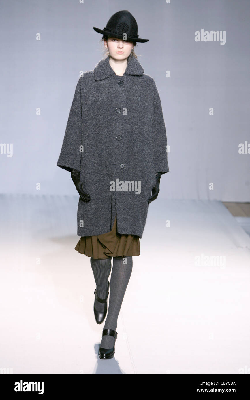 Nicole Farhi London Ready to Wear Autumn Winter  Oversize grey coat, brown skirt, grey tights, bar shoes, leather gloves and Stock Photo