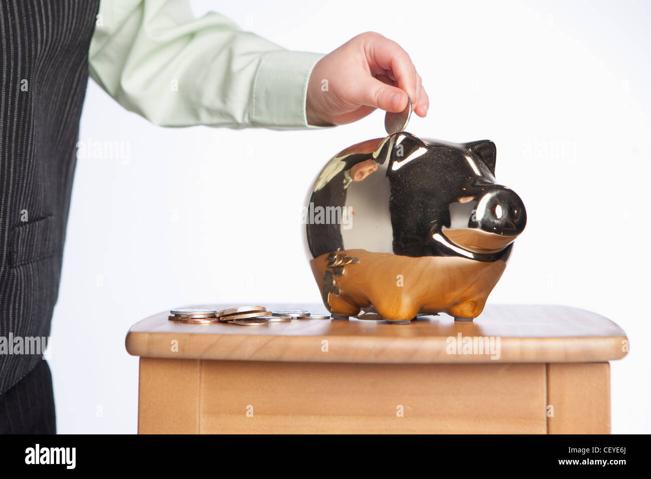a young boy puts money into a piggy bank; edmonton alberta canada Stock