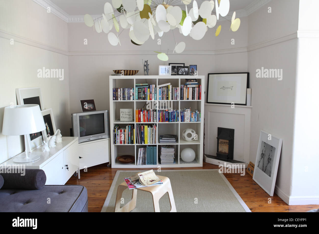 Apartment in Sydney Living room interiwith corner sofa from Habitat, white metallic low cabinet from Ikea, Butterfly pendant Stock Photo