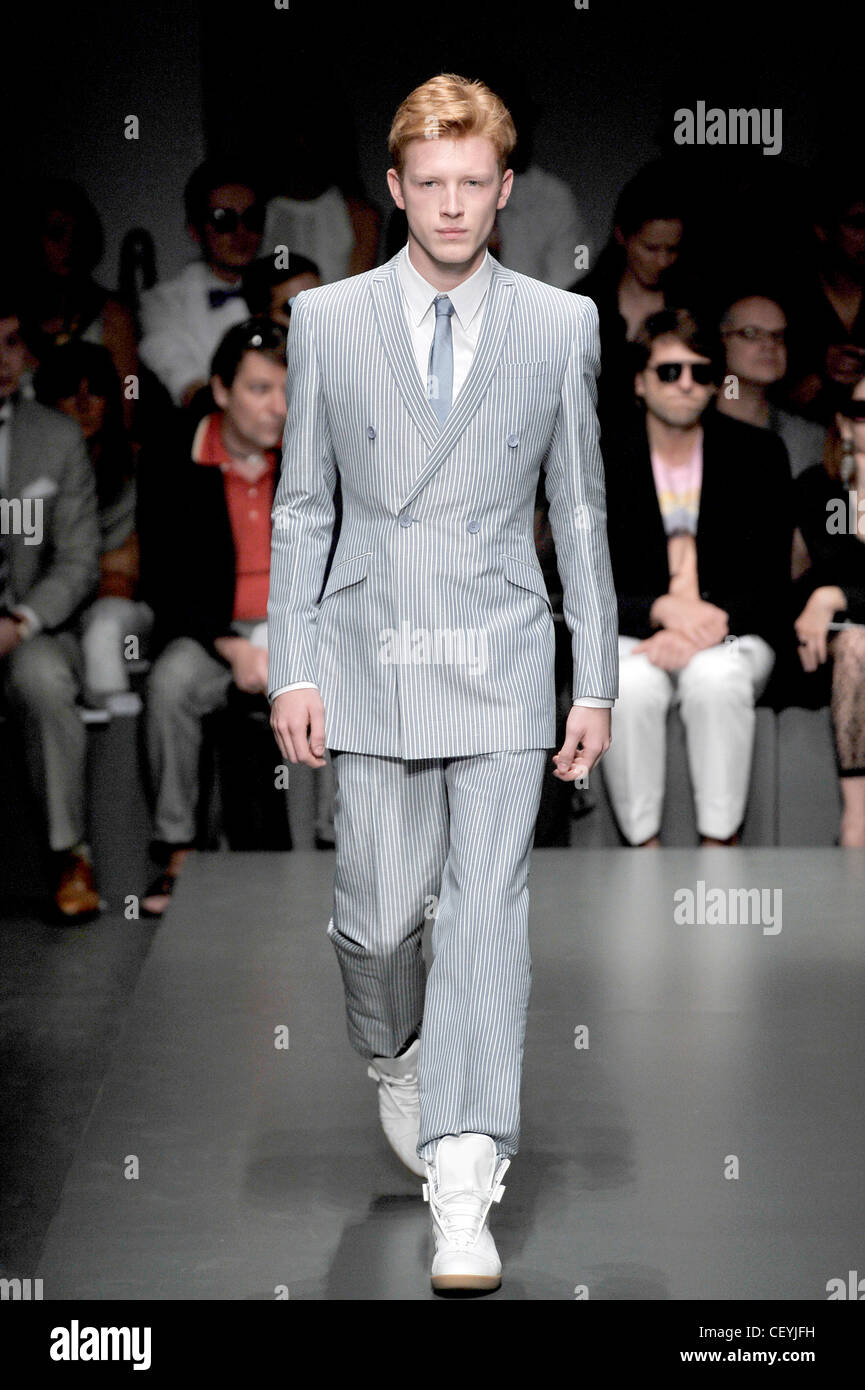 Gianfranco Ferre Milan Ready to Wear Spring Summer Male wearing light blue  pinstriped suit, and white trainers Stock Photo - Alamy
