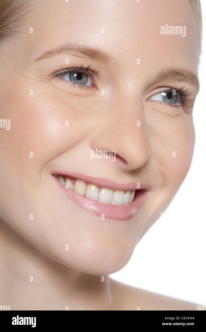 Female wearing subtle make up, smiling, looking to the side Stock Photo