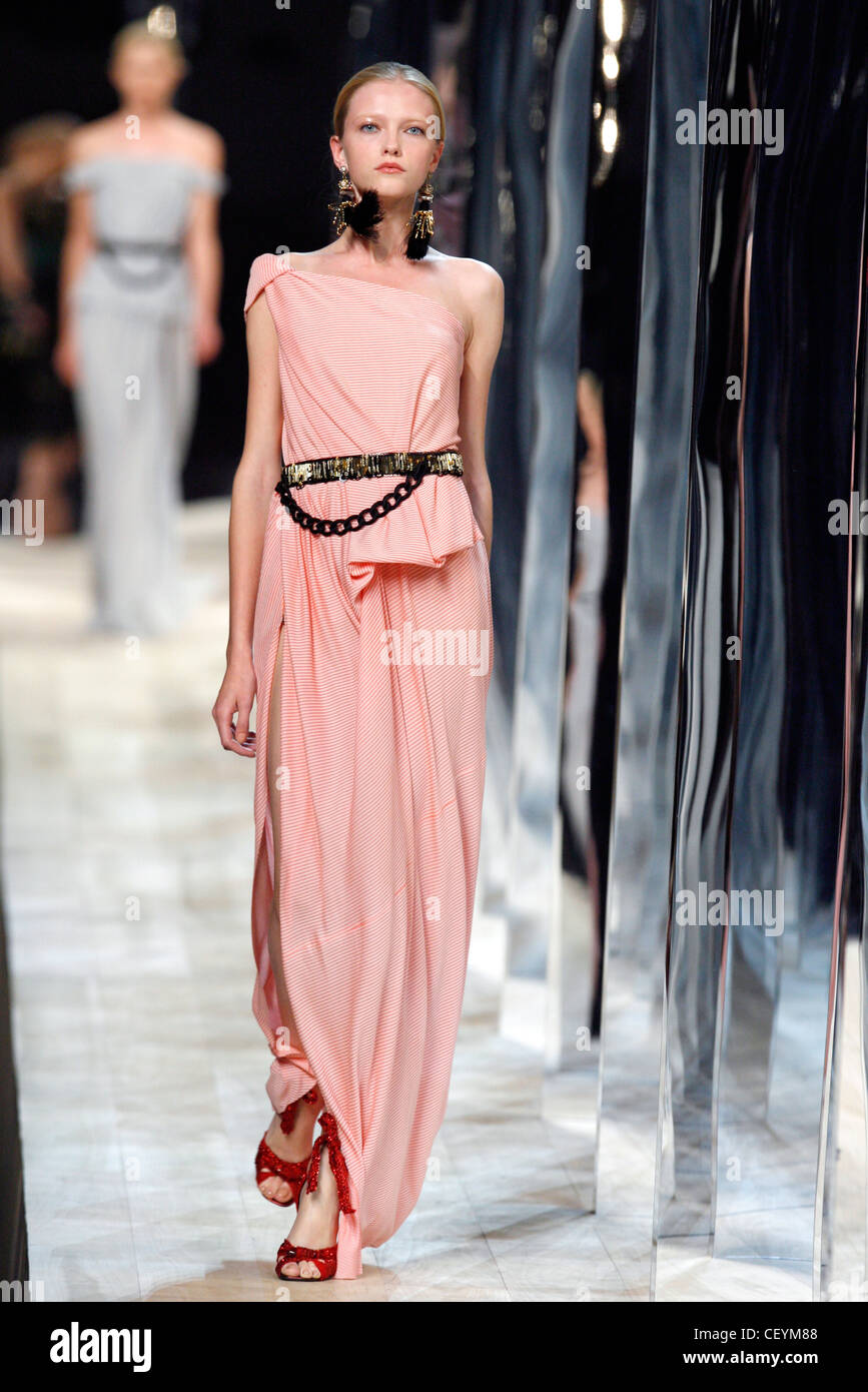 Model wearing a oversized black drop earrings, a pink asymmetric ...