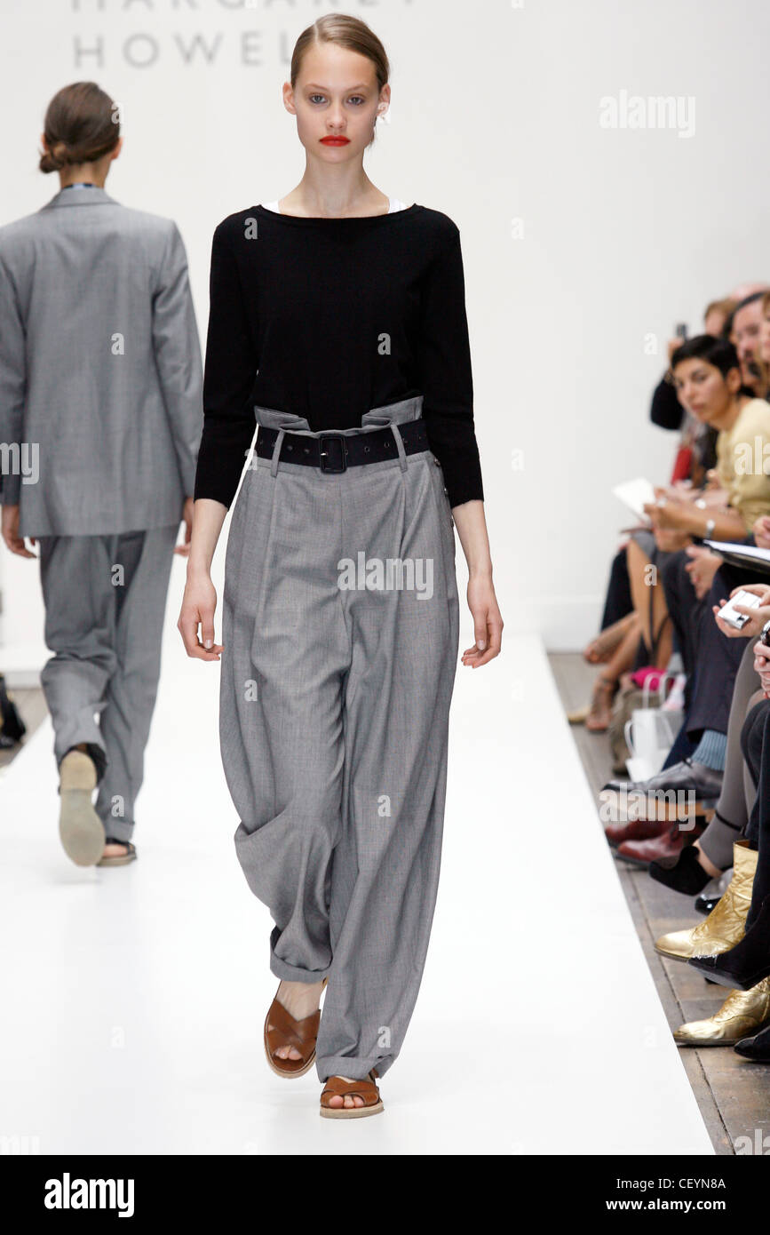 Long sleeved black blouse and high waisted grey baggy trousers and ...