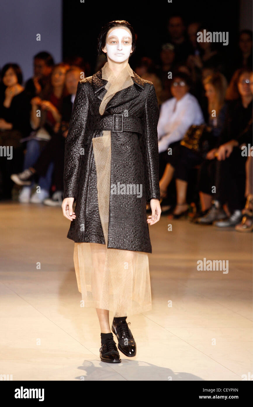 Comme des Garcons Paris Ready to Wear Spring Summer Female face painted white wearing black quilted leather coat matching belt Stock Photo Alamy