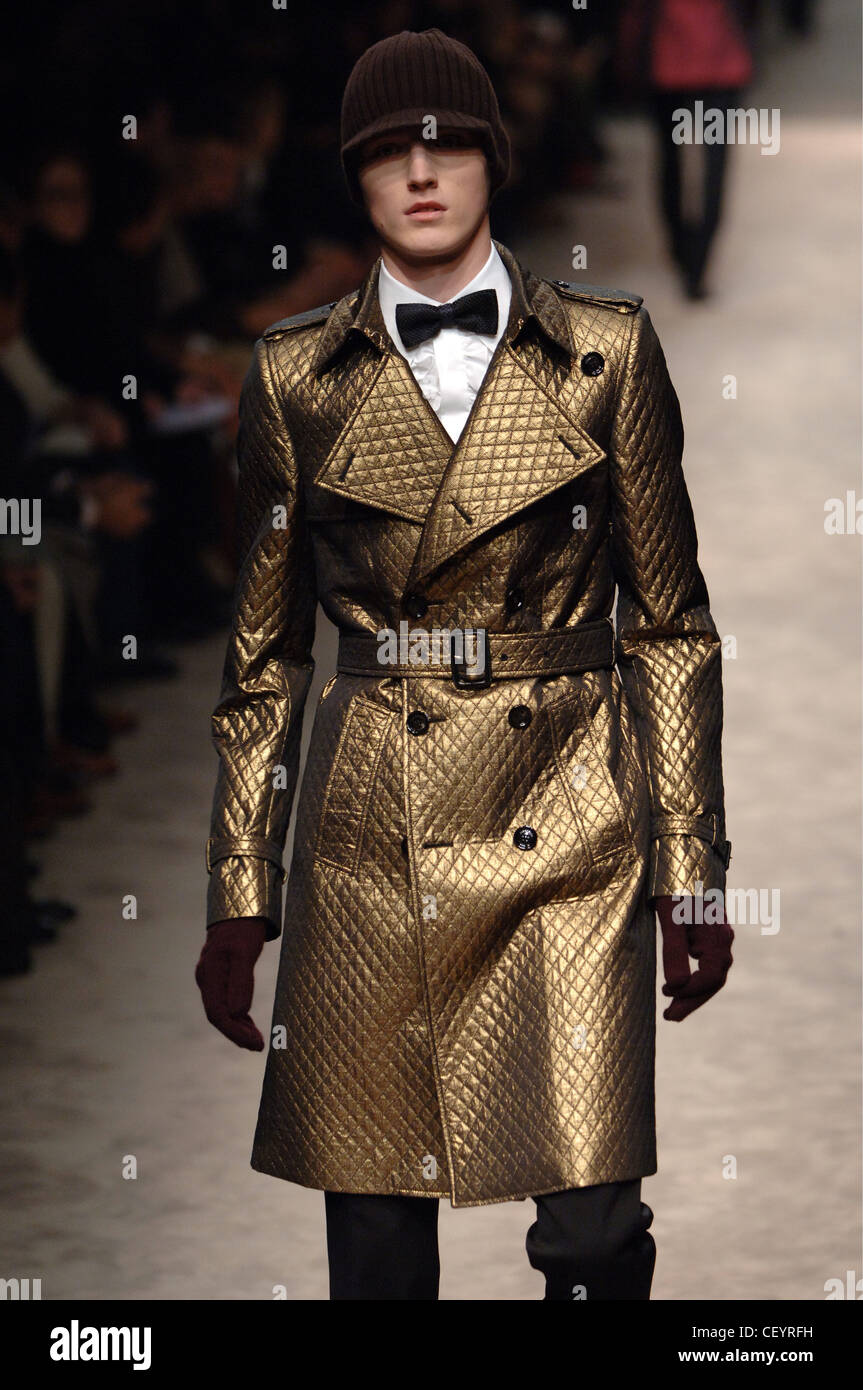 Burberry Menswear Milan A W Male model wearing a double breasted, belted  shiny gold metallic quilted knee length trench coat Stock Photo - Alamy